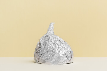 Aluminium foil hat on beige background, symbol for conspiracy theory and mind control protection....