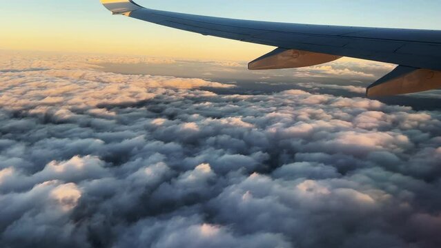 Airplane flight. Wing of an airplane flying above the clouds. View from the window of the plane. Aircraft. Traveling. 4K video footage