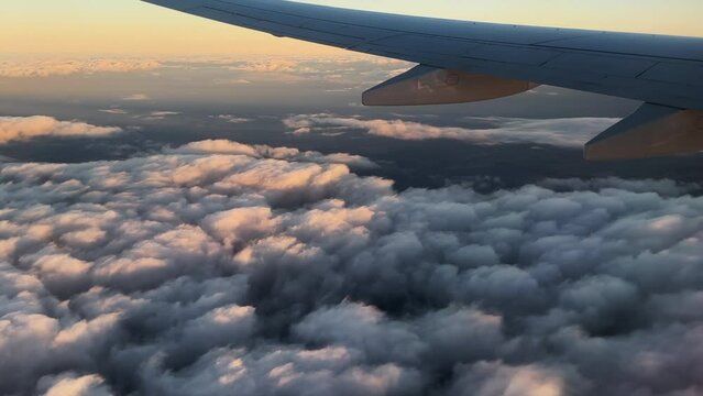 Airplane flight. Wing of an airplane flying above the clouds. View from the window of the plane. Aircraft. Traveling. 4K video footage