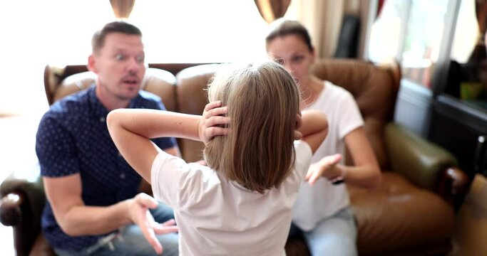 Mother and father yell at little daughter and scold. Girl does not listen, ignoring parents and covering ears