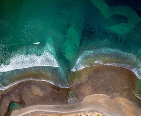 an ocean shoreline with a sandy beach area and lush vegetation in the background, Baja beach