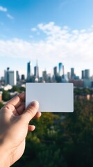 A person holding a business card with a city skyline