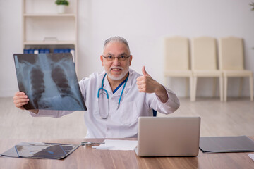 Old male doctor radiologist working in the clinic