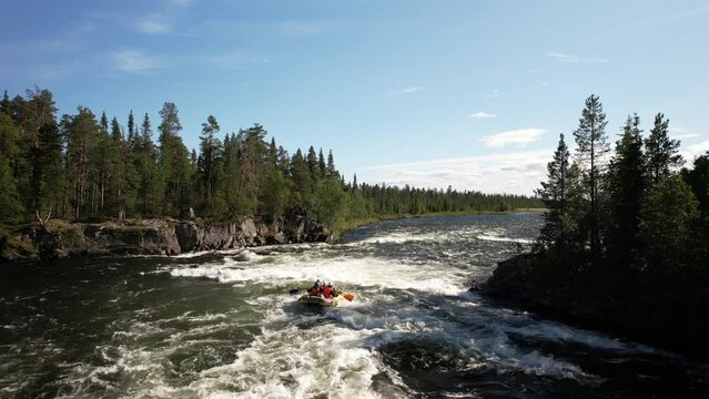 the drone flies over a stormy mountain river that flows in the middle of a dense taiga forest rafting team rafts on the waves tossing the boat 4k high quality footage Umba Kola peninsula waterfall 