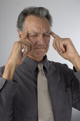 Senior Business Man CEO in deep thought with fingers against his temple thinking of new Ideas