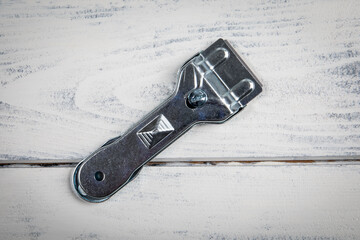 Glass ceramic scraper on a white wooden background