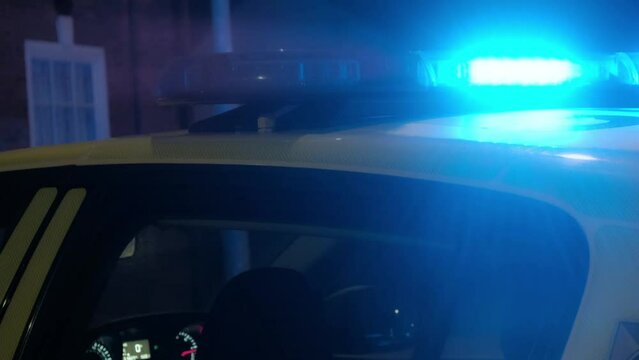 UK Police car parked in city center street. Hazard / emergency car blue lights flashing