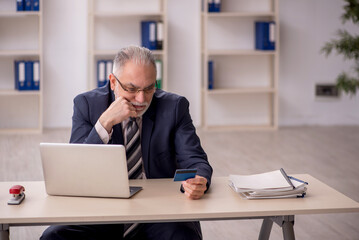 Naklejka premium Old male employee holding credit card