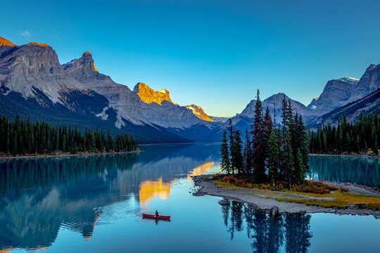 a tranquil mountain lake, surrounded by majestic snow-capped mountains, Morine lake Canada