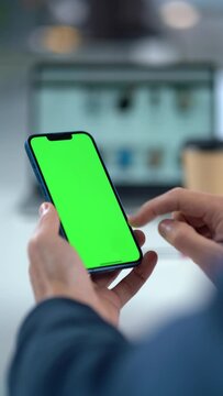 Close-up Of Mobile Phone With Green Mock-up Screen In Men's Hands On Desktop Background. Man Using Smartphone, Browsing Internet, Social Networks, Financial Reports