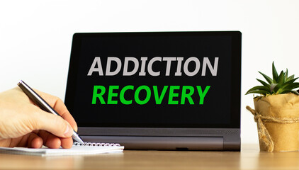 Addiction recovery symbol. Concept words Addiction recovery on beautiful black tablet. Beautiful white background. Psychologist hand. Psychology addiction recovery concept. Copy space.