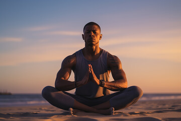 A black man doing yoga at the beach in a lotus position wearing sports clothes - obrazy, fototapety, plakaty
