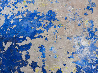 Abstract blue grunge background. Weathered cement wall with peeling blue paint. Aged scratched cement wall. Colorful grungy concrete wallpaper. Old wall texture with copy space.