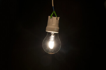 Glowing light bulb close up on a black background