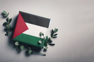 Palestinian flag among green branches on a blank background. Space for text.