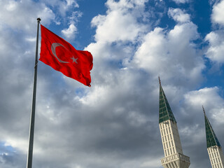  Turkish flag waving in blue cloudly sky with minaret of mosque. 19 mayis, 23 nisan, 15 temmuz, 30...