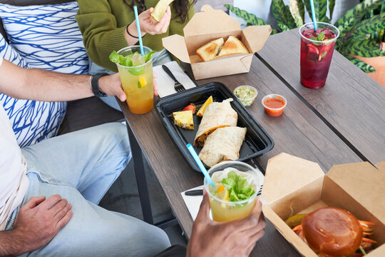Friends eating takeout food at table