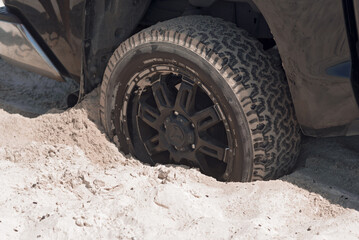 Fototapeta na wymiar Stuck Vehicle Tire in Sandy Terrain