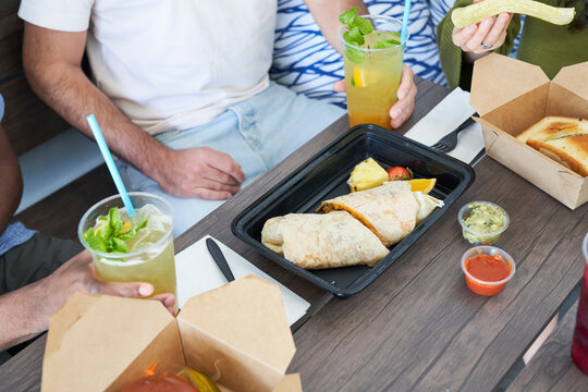 Friends eating takeout food at table