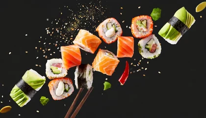 Crédence de cuisine en verre imprimé Bar à sushi Flying pieces of sushi rolls on a black background close-up. Traditional Japanese cuisine