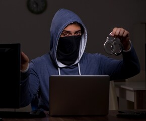 Male hacker hacking security firewall late in office
