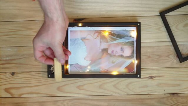 The process of packing wedding photos in a beautiful wooden box.