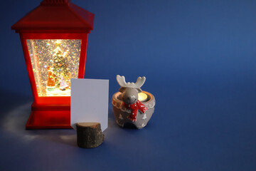 Christmas decorations with copy space. Lantern and empty greeting card with candle.