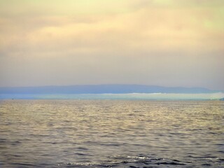 Obraz premium A tranquil and minimal seascape, toned in pale golden yellow with a strip of blue on the horizon.