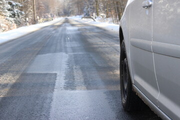 Auto mit Winterreifen auf einer verschneiten Straße