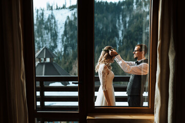 the groom puts a wreath on the bride against the background of snow-capped mountains. A wedding...