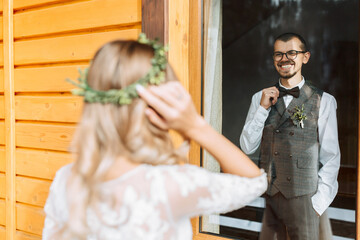 Fototapeta na wymiar the first meeting of the bride and groom. He looks at her. Handsome and smiling young groom. Wedding in a rustic style