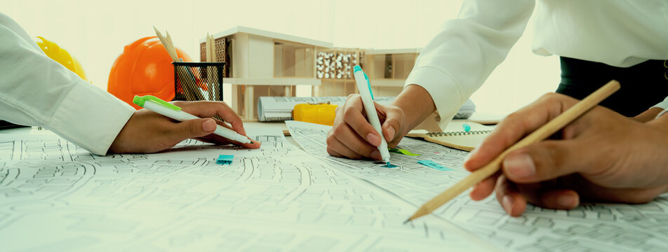 Worker, architect and engineer work on real estate construction project oratory planning with cartography and cadastral map of urban town area to guide to construction developer business plan of city