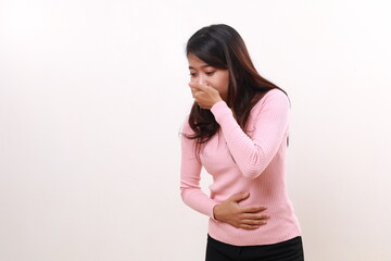 Young asian girl holding her belly and covering mouth. Feels nauseous concept. Isolated on white...