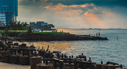 Fishing in the Morning, a group of people fishing on a rocky shore next to the sea on Sunday morning.