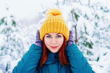 Young smiling woman enjoys snowy winter day. High quality photo