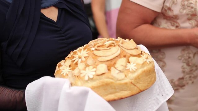 Slavic wedding tradition, parents offer bread salt to bride groom. Festive loaf presented at ceremony, symbol for prosperity, happiness in marriage. Ethnic ritual, cultural heritage, nuptial custom.