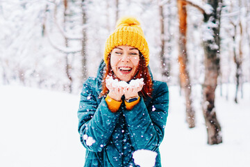 Young smiling woman enjoys snowy winter day. High quality photo