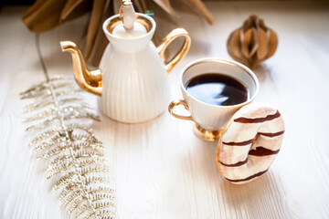 Cup of coffee and chocolate donuts on a white wooden background. Handmade Kraft Paper Christmas Decorations