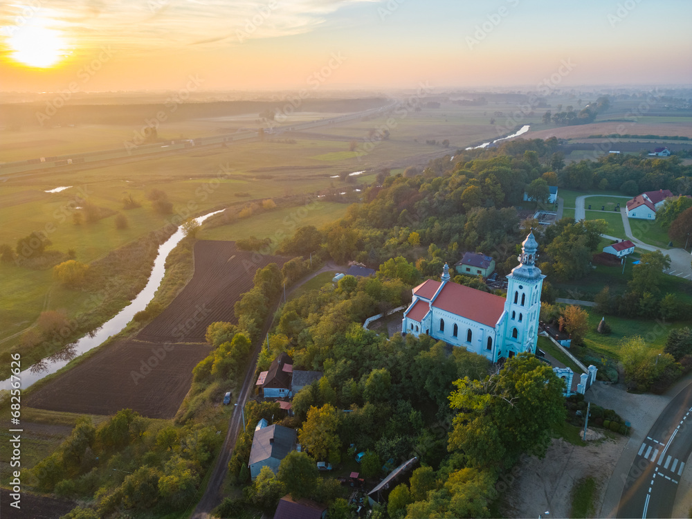 Wall mural aerial autumn view at church in chelmno on the ner river, a village in poland