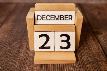 Cube shape calendar for December 23 on wooden surface with empty space for text,cube calendar for december