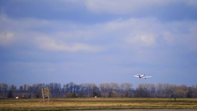 White little plane is rising in the air. Aircraft is flying above the field in autumn.