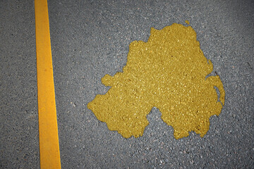 yellow map of northern ireland country on asphalt road near yellow line.