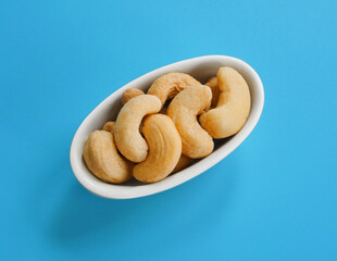 Bowl or dish of raw organic cashews that are salted and roasted
