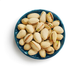 Bowl or dish of raw organic pistachios that are salted and roasted on a white background