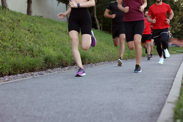 Group of people running outdoors, closeup view