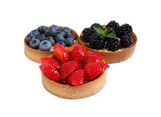 Tartlets with different fresh berries isolated on white. Delicious dessert