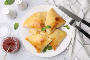 Delicious samosas served on white textured table, flat lay