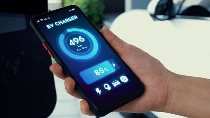Smartphone display battery status on smart EV mobile application while EV car recharging...