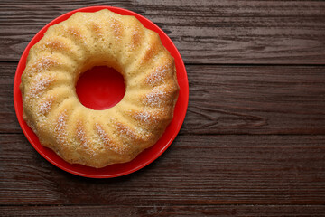 Delicious freshly baked sponge cake on wooden table, top view. Space for text