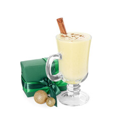 Delicious eggnog with cinnamon and Christmas gift isolated on white